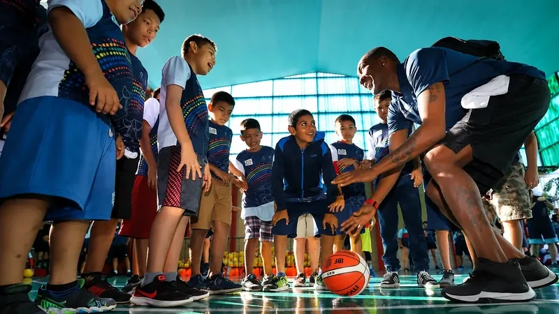 Cory McGee coaching a group of kids at a basketball clinic
