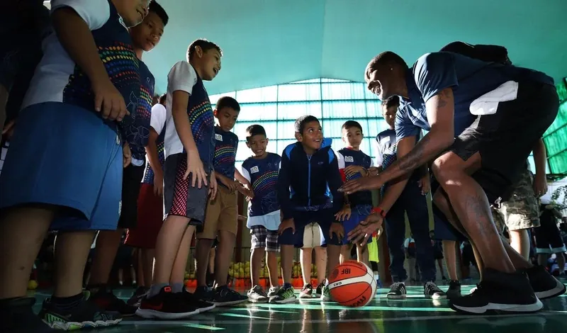Youth basketball clinic team huddle with Cory McGee